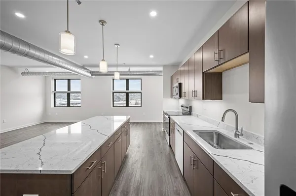 a kitchen with granite countertop a sink a counter space appliances and cabinets