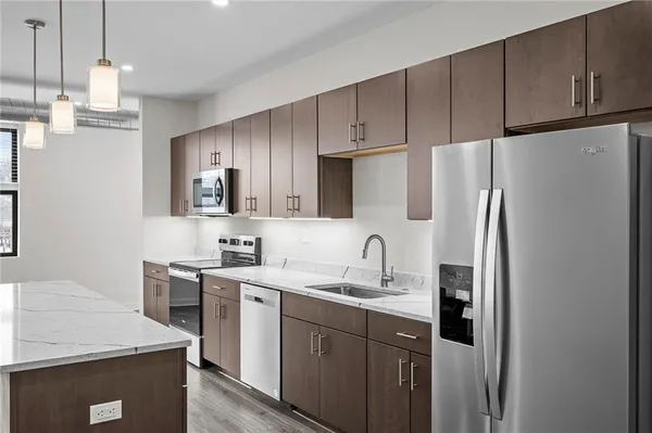 a kitchen with stainless steel appliances a refrigerator sink and cabinets