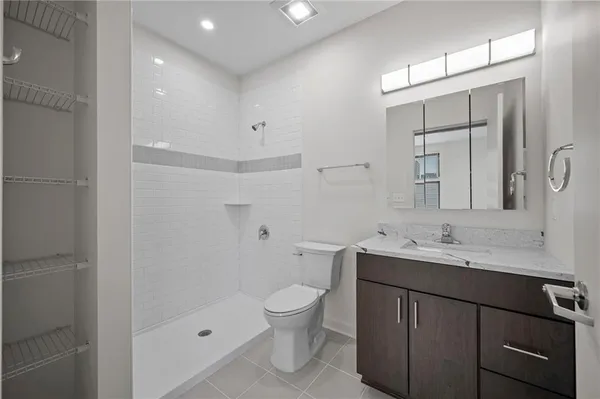 a bathroom with a toilet a sink a mirror and a shower