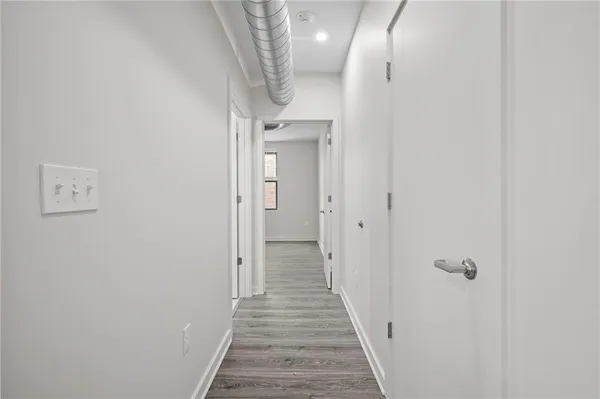 a view of a hallway with wooden floor and entryway