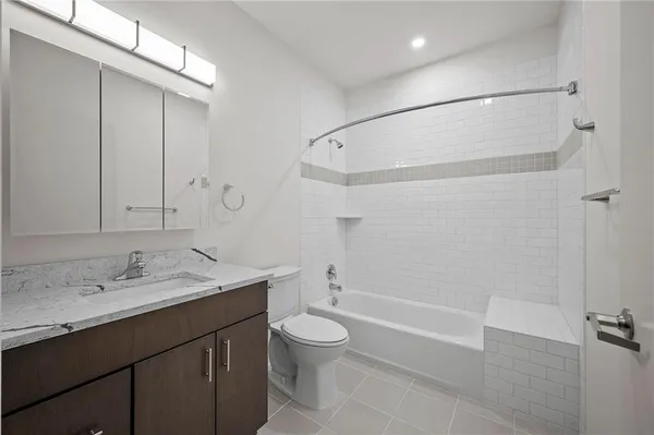 a bathroom with a granite countertop sink a toilet and shower
