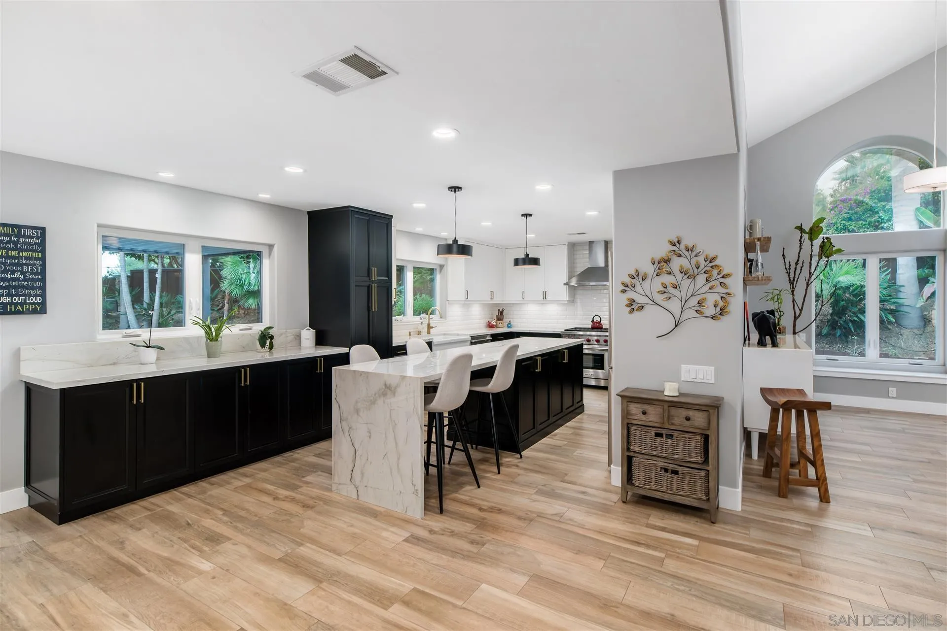 815 Marisa Lane Encinitas, CA 92024 - Photo 9 of 41 a kitchen with stainless steel appliances kitchen island granite countertop a refrigerator and cabinets