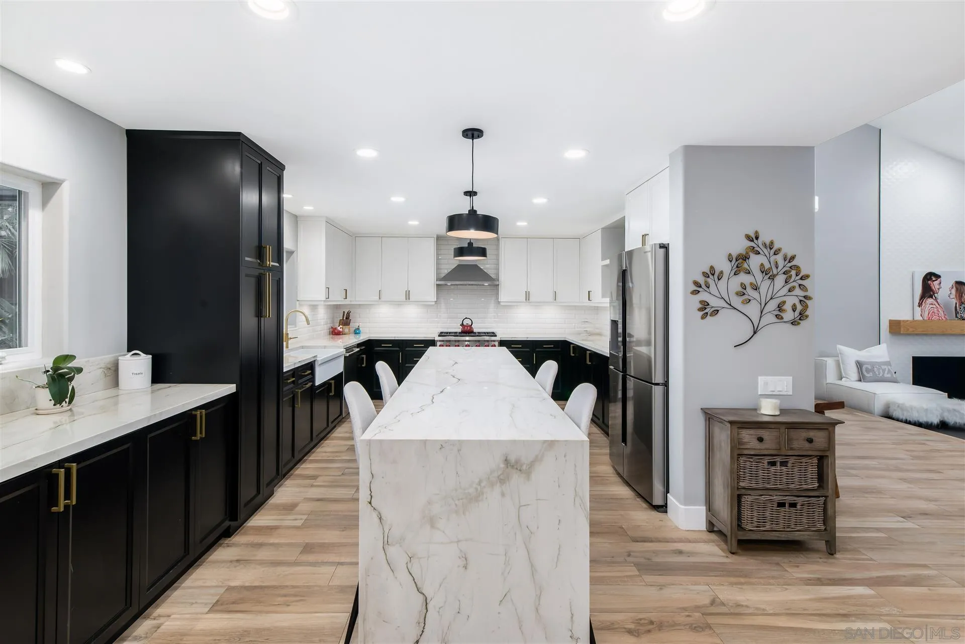 815 Marisa Lane Encinitas, CA 92024 - Photo 10 of 41 a large kitchen with stainless steel appliances kitchen island granite countertop a large kitchen island a stove a refrigerator a sink and a dining table with wooden floor