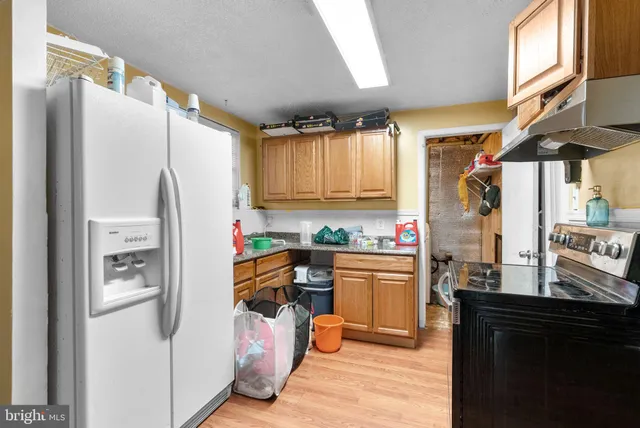a kitchen with stainless steel appliances a refrigerator and a stove top oven