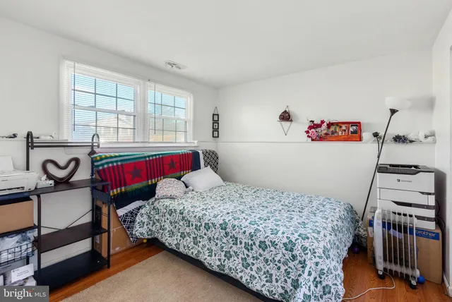 a bedroom with a bed and dresser with windows