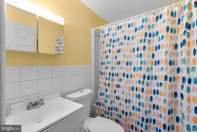 a bathroom with a sink and mirror with toilet