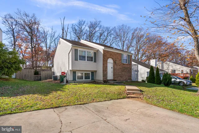 a view of a white house with a big yard and large trees