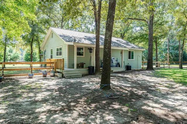 a view of a house with a yard and large tree