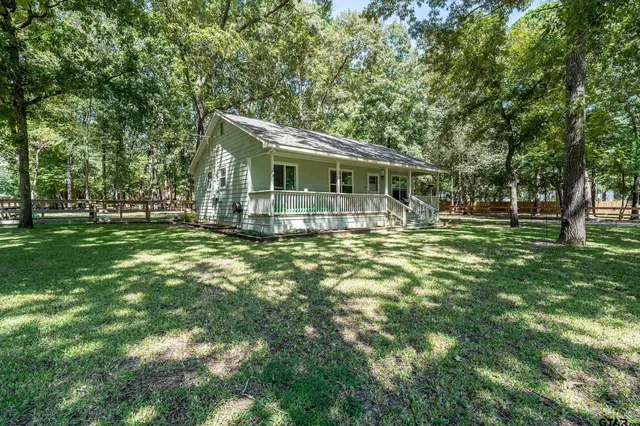 a backyard of a house with yard table and chairs