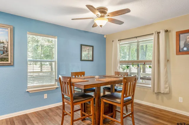 a dining room with furniture a chandelier and wooden floor