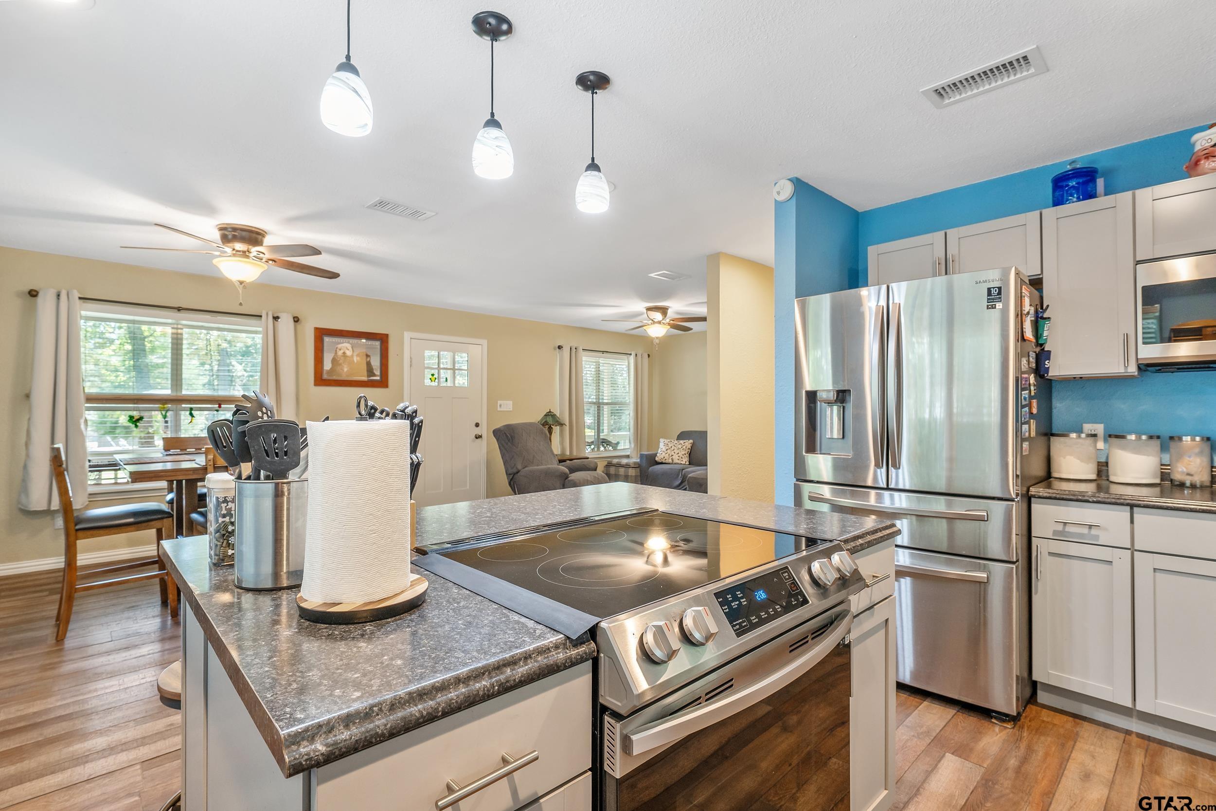 230 Deborah Street Bullard, TX 75757 - Photo 7 of 23 a kitchen with stainless steel appliances granite countertop a stove refrigerator and chairs