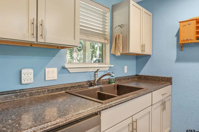 a kitchen with stainless steel appliances granite countertop a sink and a white cabinets