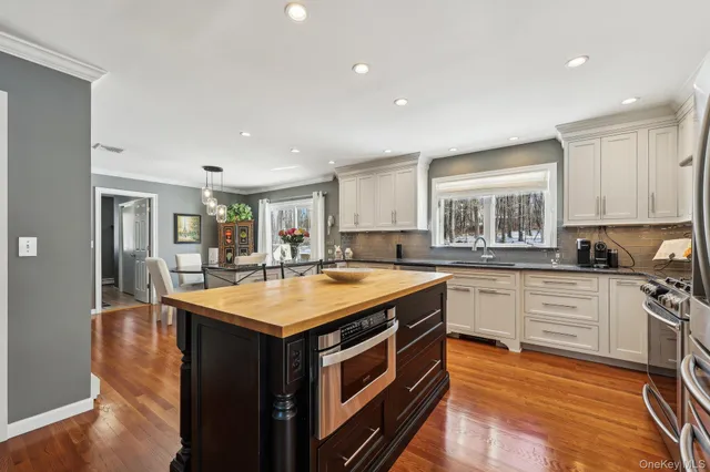 a kitchen with stainless steel appliances granite countertop a stove a refrigerator and a white cabinets