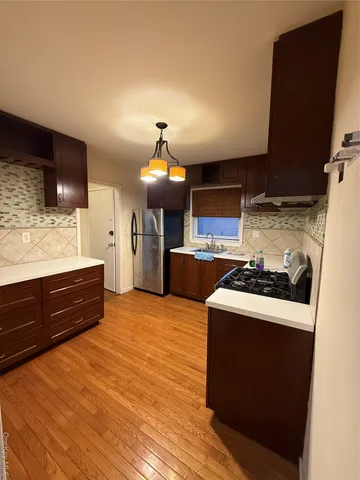 a kitchen with stainless steel appliances granite countertop a sink a stove and a refrigerator