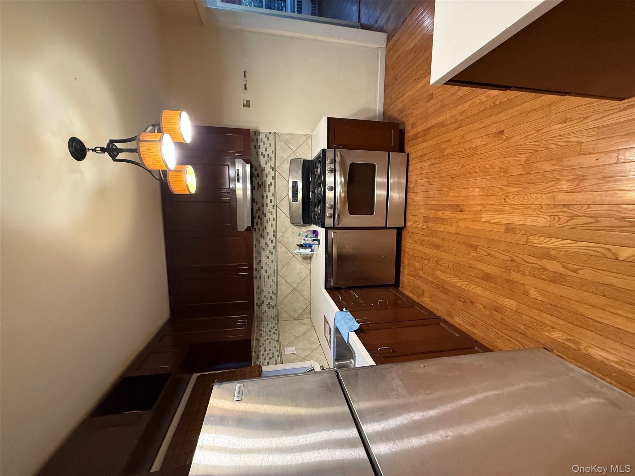 109-11 225th Street, Unit 2 Queens, NY 11429 - Photo 5 of 13 a kitchen with stainless steel appliances granite countertop a refrigerator a stove a sink and a microwave