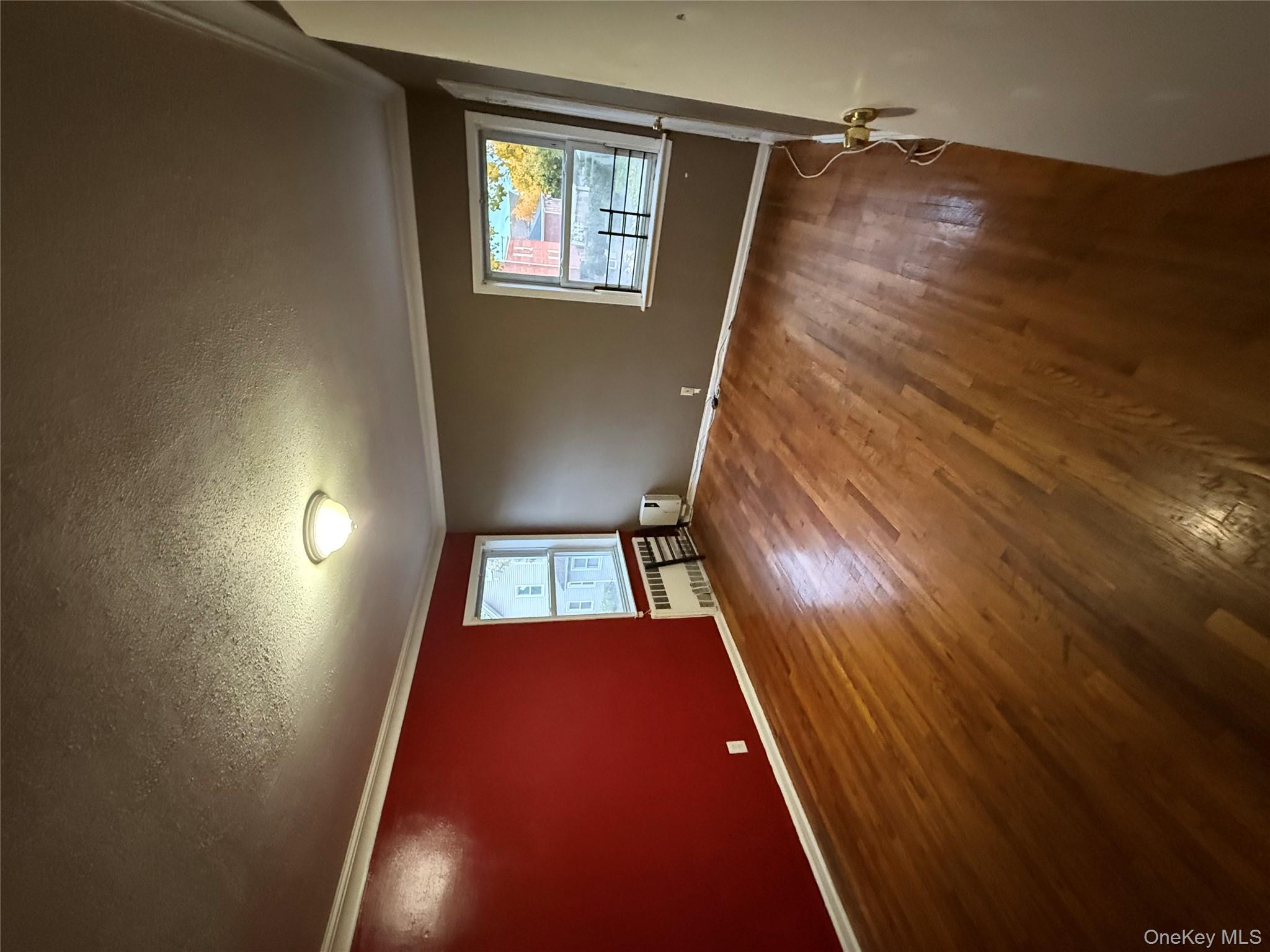 109-11 225th Street, Unit 2 Queens, NY 11429 - Photo 10 of 13 an empty room with wooden floor and windows