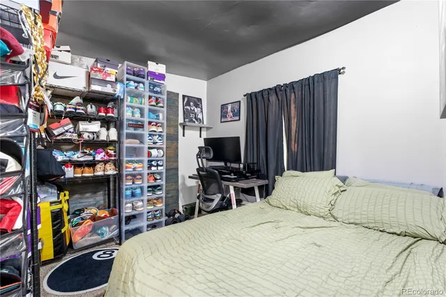 a bedroom with a bed a flat screen tv and a desk
