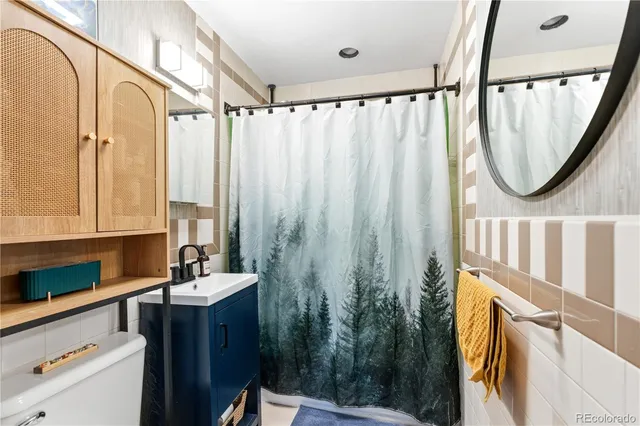 a bathroom with a sink a mirror a vanity and a shower