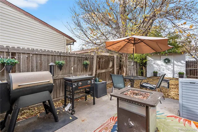 a patio with a table and chairs under an umbrella
