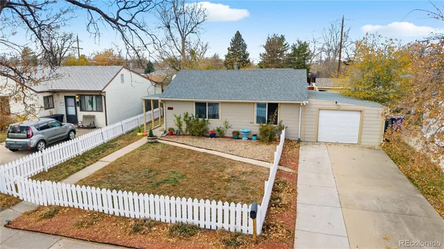 a view of a house with a small yard and large tree