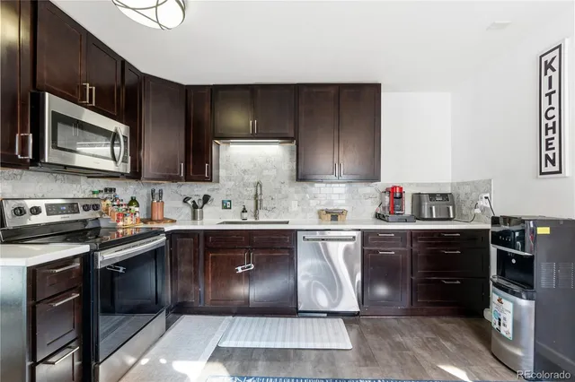 a kitchen with stainless steel appliances granite countertop a sink and stove top oven