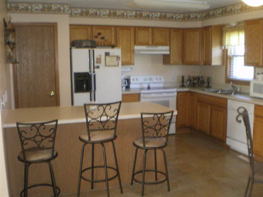 6780 Friday Road Byron, IL 61010 - Photo 5 of 6 a kitchen with stainless steel appliances kitchen island granite countertop a table chairs and a refrigerator