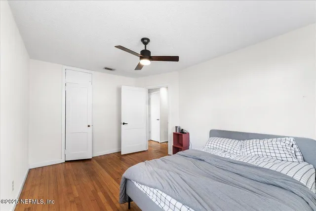 a bedroom with a bed and a ceiling fan