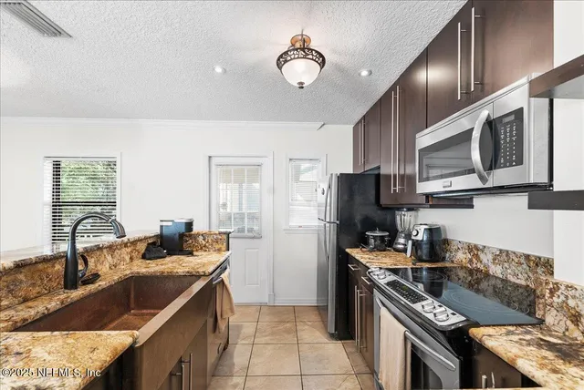 a kitchen with stainless steel appliances granite countertop a sink stove and refrigerator