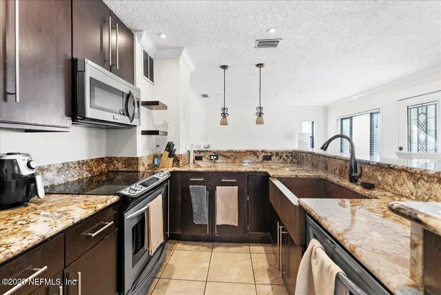 a kitchen with stainless steel appliances granite countertop a sink stove and cabinets