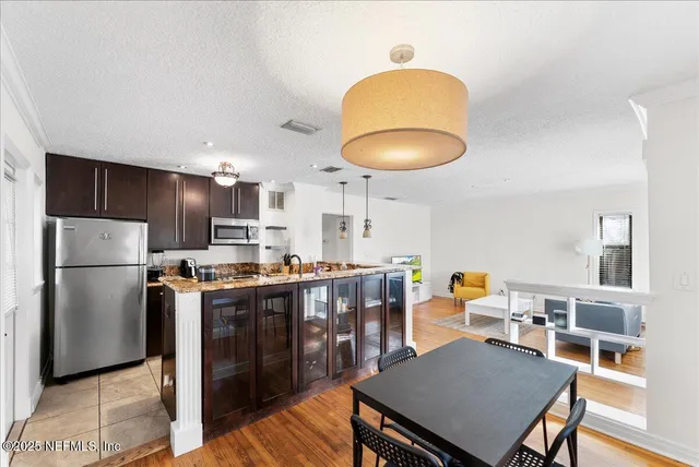 a kitchen with stainless steel appliances a table and chairs in it
