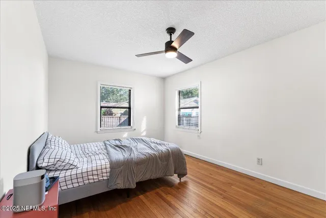 a bedroom with a bed and wooden floor