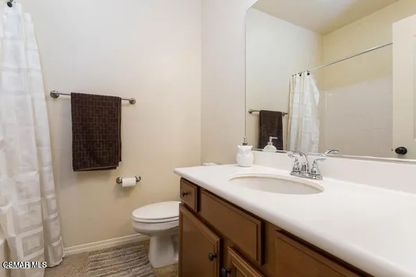 a bathroom with a granite countertop sink toilet a mirror and a bathtub