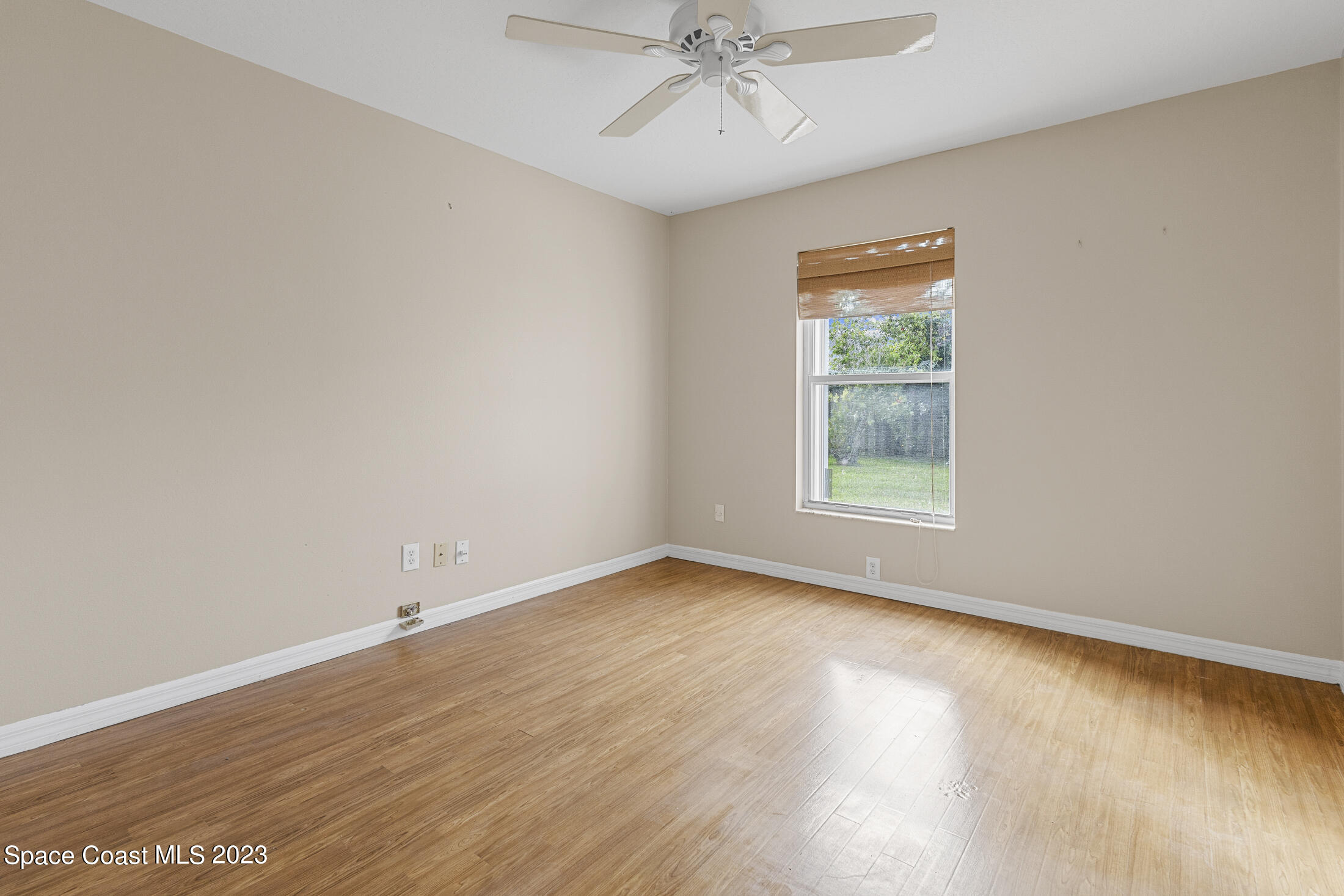 813 Cebu Place Melbourne, FL 32940 - Photo 11 of 25 an empty room with wooden floor chandelier fan and windows
