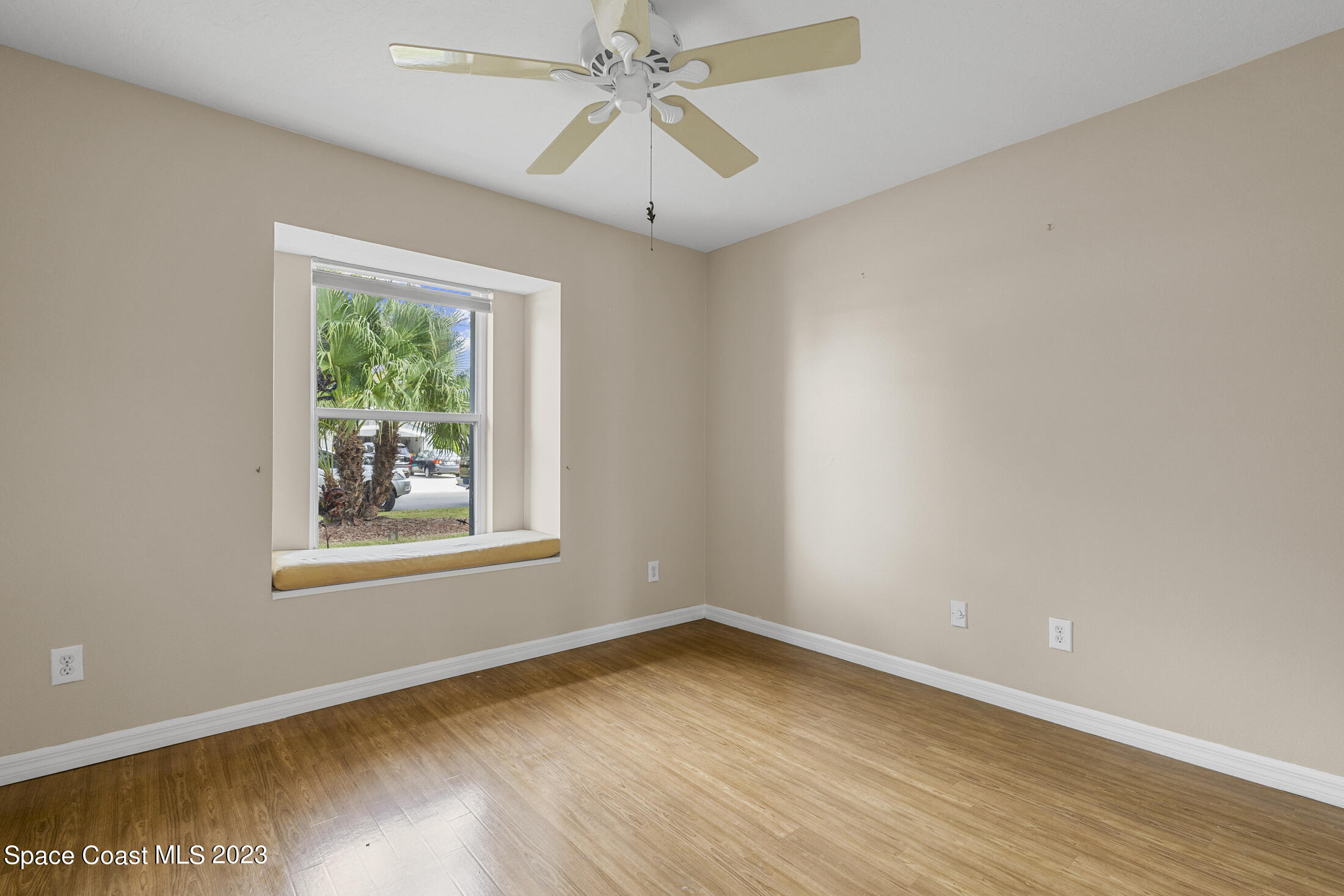 813 Cebu Place Melbourne, FL 32940 - Photo 14 of 25 an empty room with wooden floor chandelier fan and windows