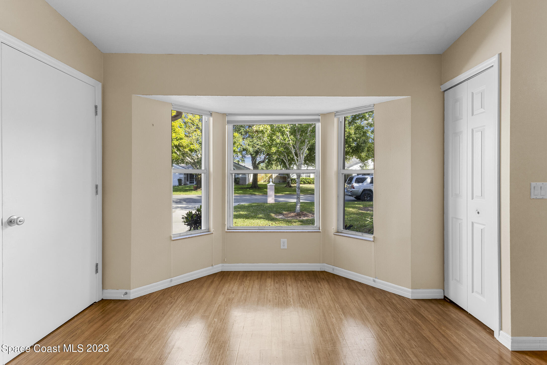 813 Cebu Place Melbourne, FL 32940 - Photo 6 of 25 an empty room with wooden floor and windows