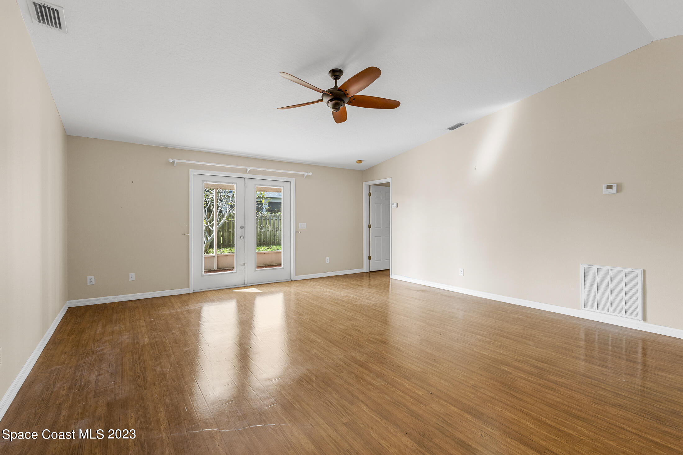 813 Cebu Place Melbourne, FL 32940 - Photo 7 of 25 a view of an empty room with window and wooden floor