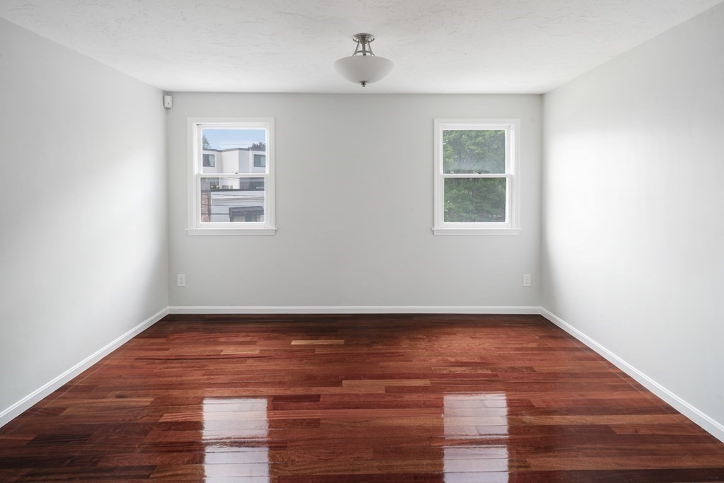 68 Regent Circle, Unit 68 Brookline, MA 02445 - Photo 12 of 21 an empty room with wooden floor cabinet and windows