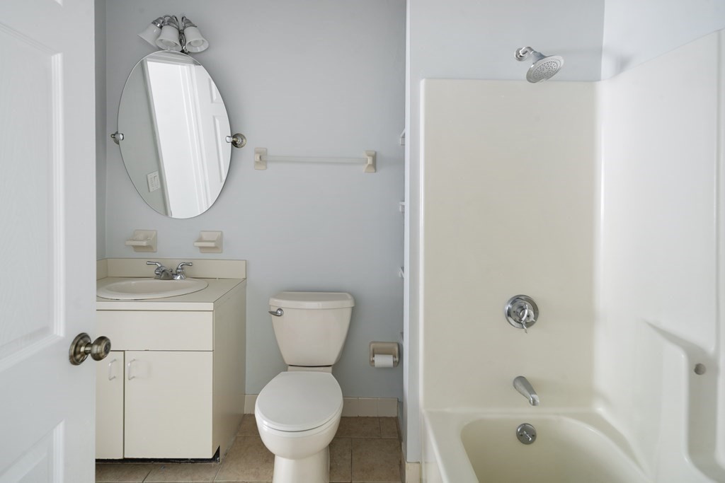 68 Regent Circle, Unit 68 Brookline, MA 02445 - Photo 16 of 21 a bathroom with a toilet sink vanity tub and mirror