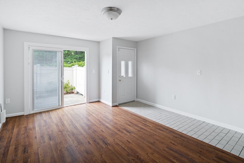 68 Regent Circle, Unit 68 Brookline, MA 02445 - Photo 4 of 21 a view of an empty room with wooden floor and a window