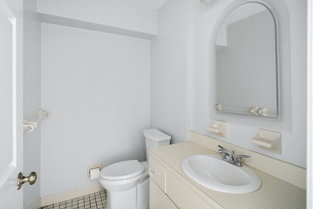68 Regent Circle, Unit 68 Brookline, MA 02445 - Photo 8 of 21 a bathroom with a sink a toilet and a mirror