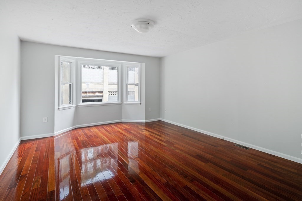 68 Regent Circle, Unit 68 Brookline, MA 02445 - Photo 9 of 21 a bedroom with a bed and wooden floor