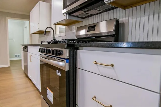 a kitchen with stainless steel appliances granite countertop a stove and a microwave