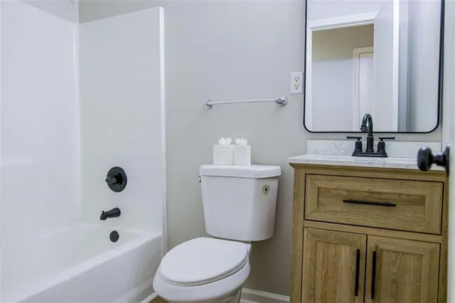 a bathroom with a granite countertop toilet a sink and a bathtub