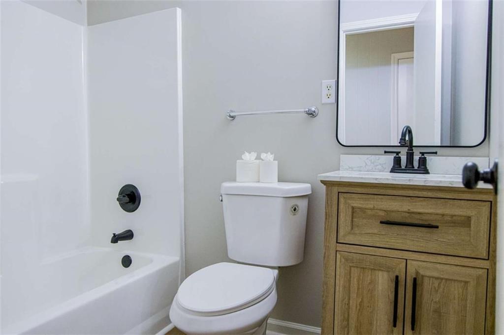 83 Manning Lake Road Rome, GA 30165 - Photo 22 of 26 a bathroom with a granite countertop toilet a sink and a bathtub