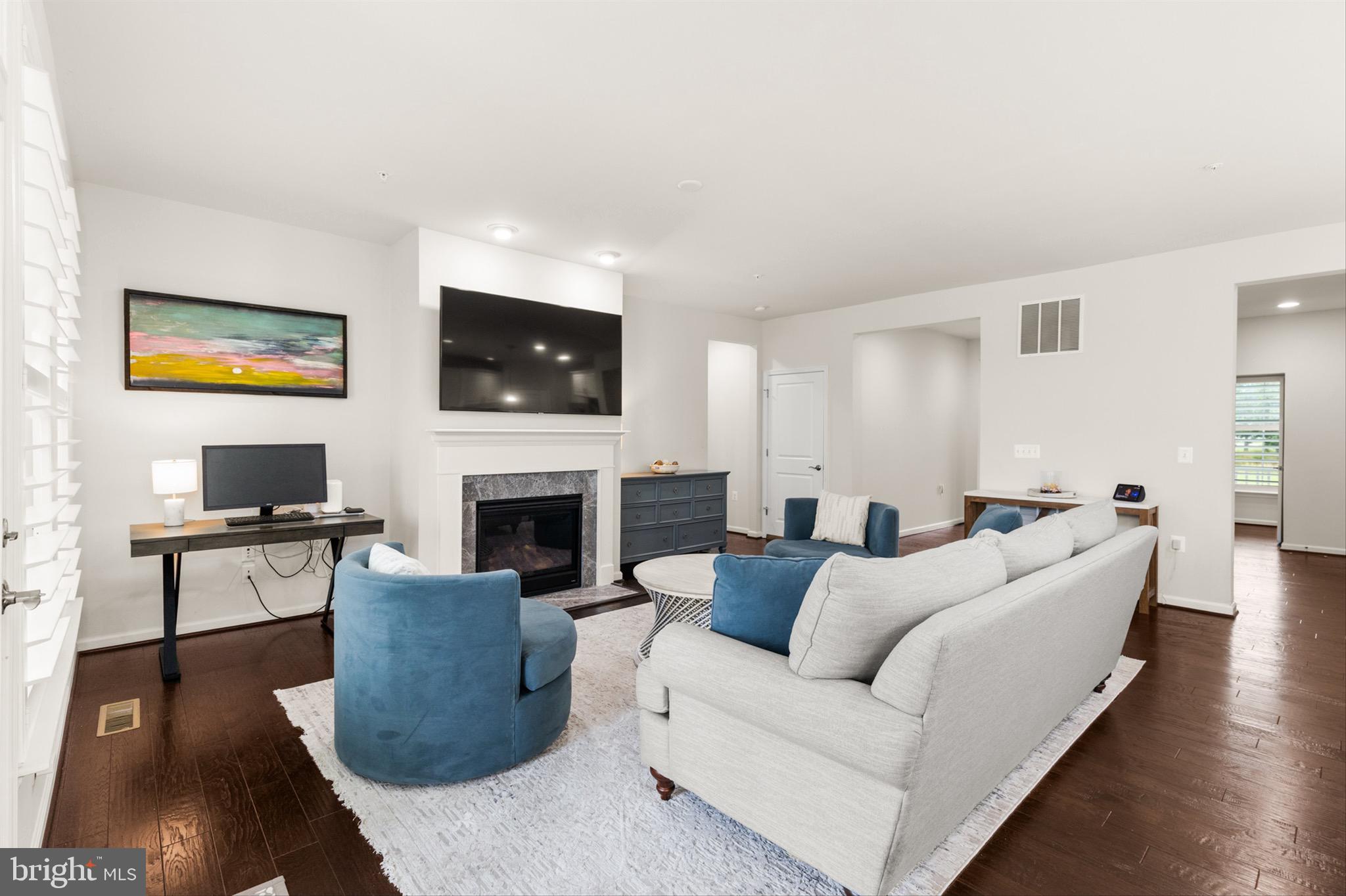 10135 Fast Colors Lane Berlin, MD 21811 - Photo 11 of 63 a living room with furniture a fireplace and a flat screen tv
