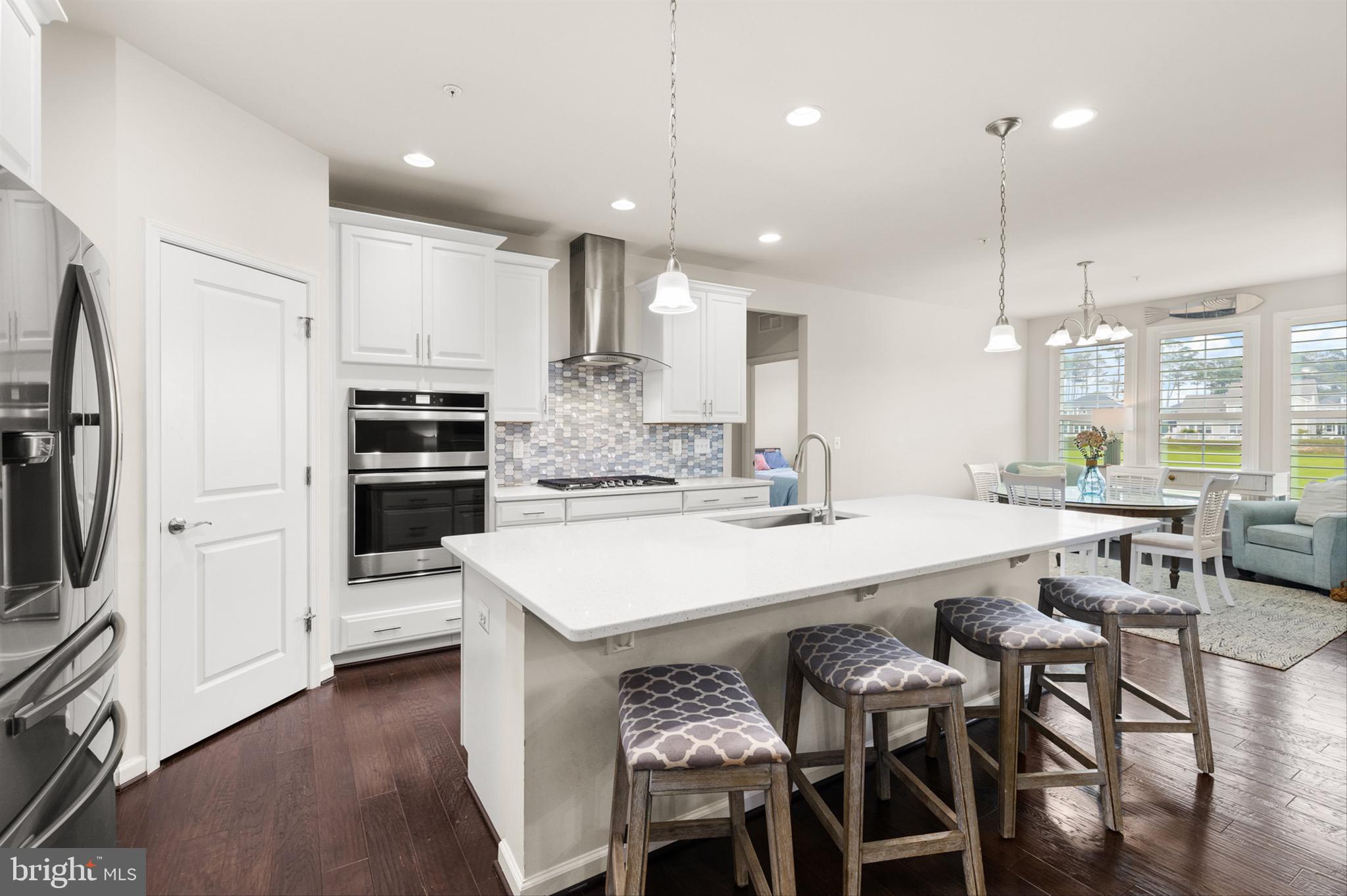 10135 Fast Colors Lane Berlin, MD 21811 - Photo 12 of 63 a large kitchen with kitchen island a table and chairs