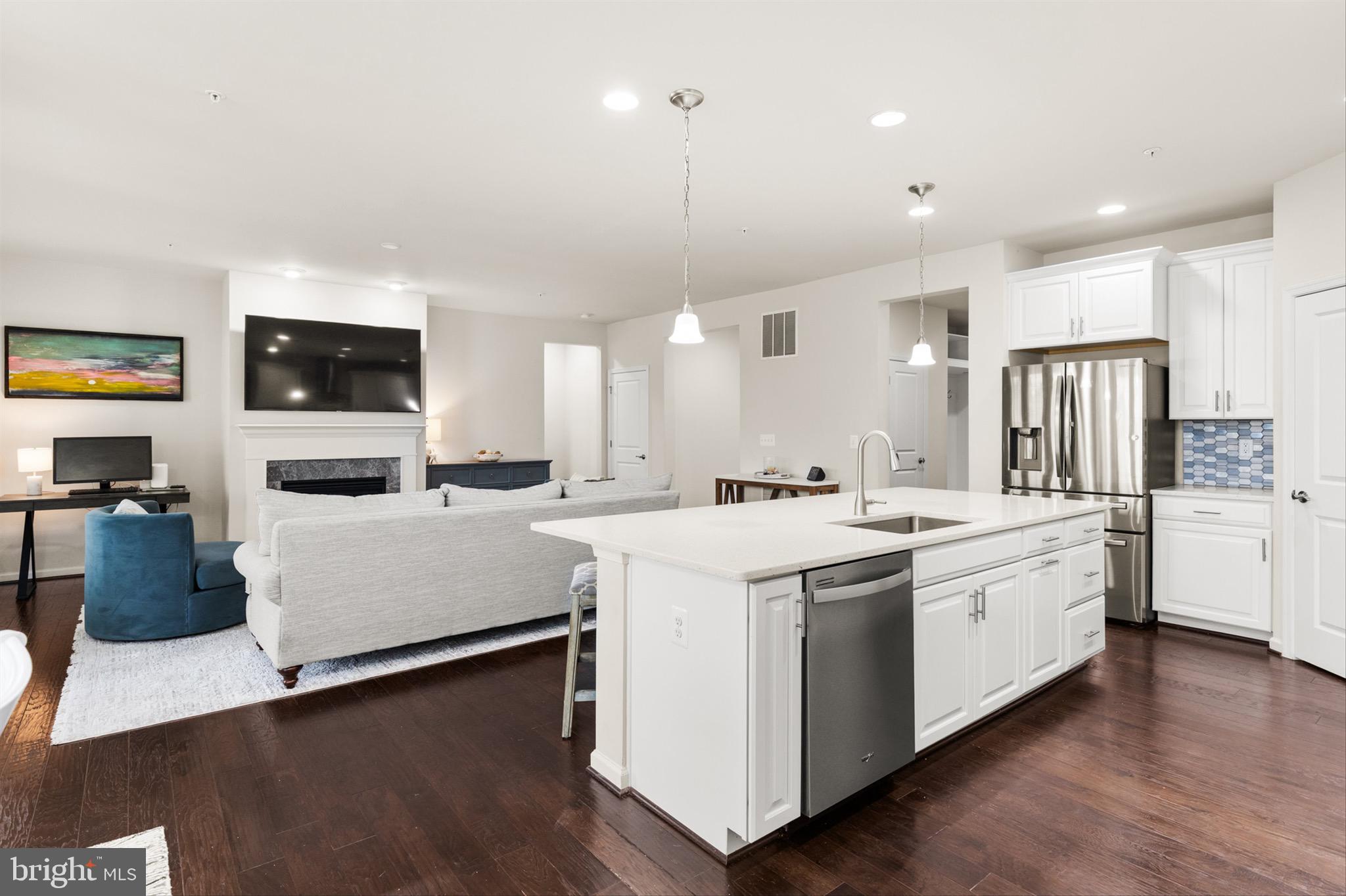 10135 Fast Colors Lane Berlin, MD 21811 - Photo 7 of 63 a large white kitchen with a stove top oven a sink dishwasher and a refrigerator with wooden floor