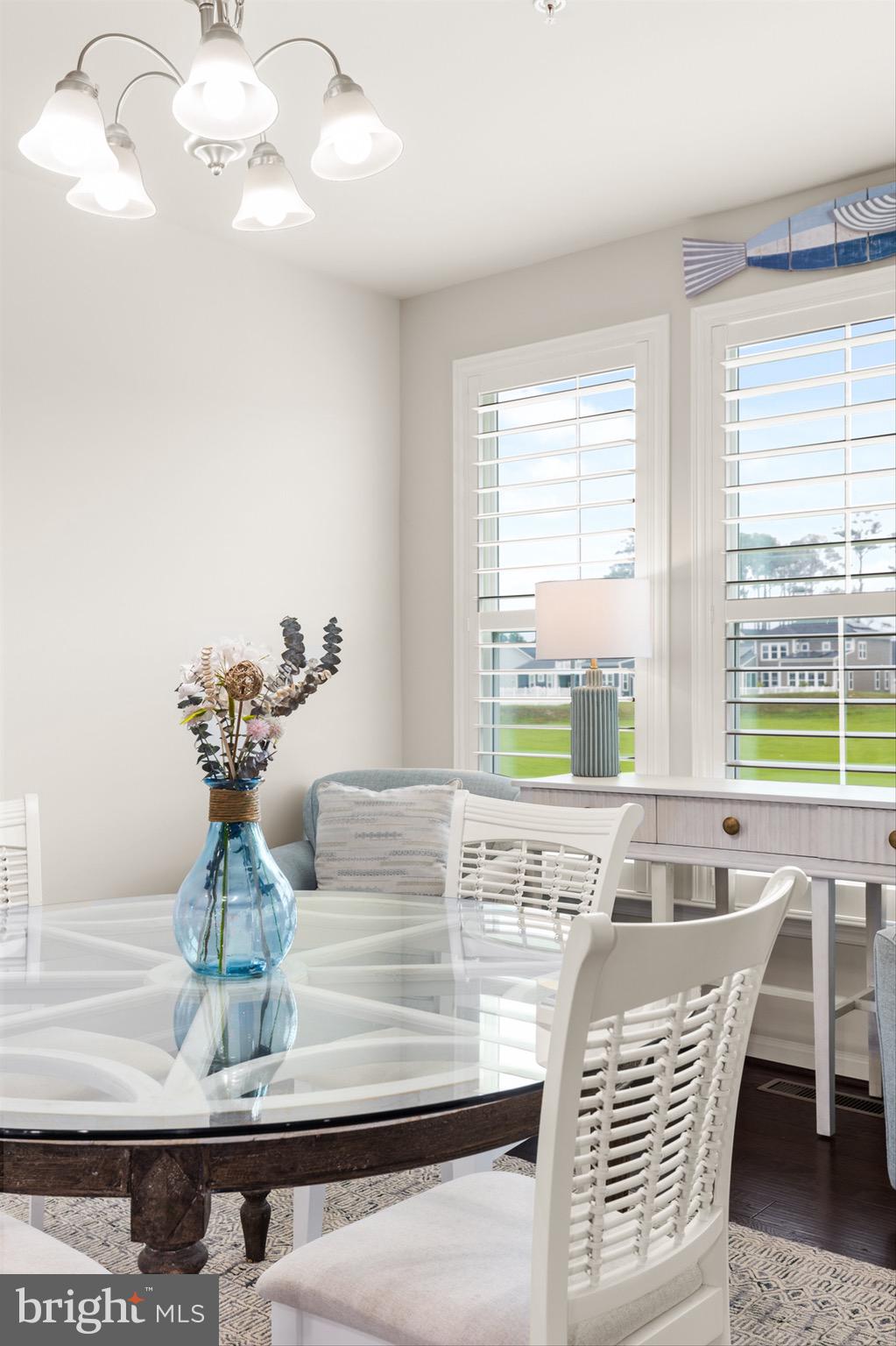 10135 Fast Colors Lane Berlin, MD 21811 - Photo 9 of 63 a view of a dining room with furniture a chandelier and large windows