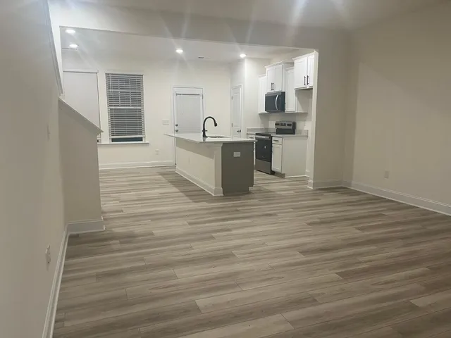 a large kitchen with stainless steel appliances granite countertop a stove and a sink