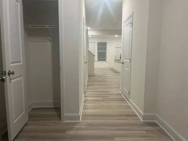 a view of a hallway with wooden floor and staircase